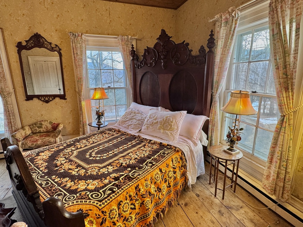 Bedroom with a carved wooden bed and patterned coverlet