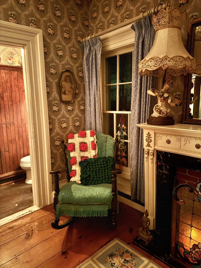 Green armchair beside an antique fireplace