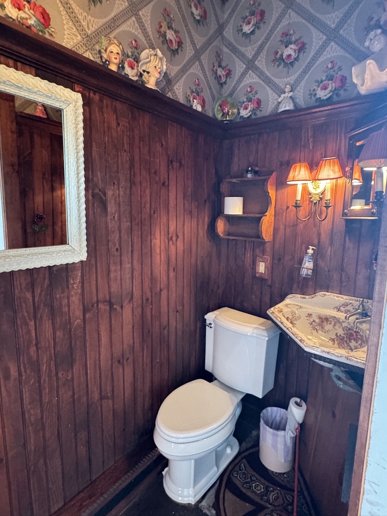 Wood-paneled bathroom with framed artwork