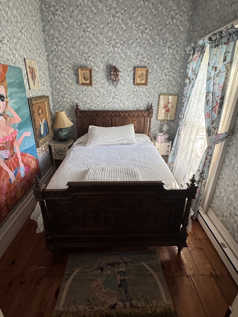 Guest bedroom with a carved bed and sunlit windows