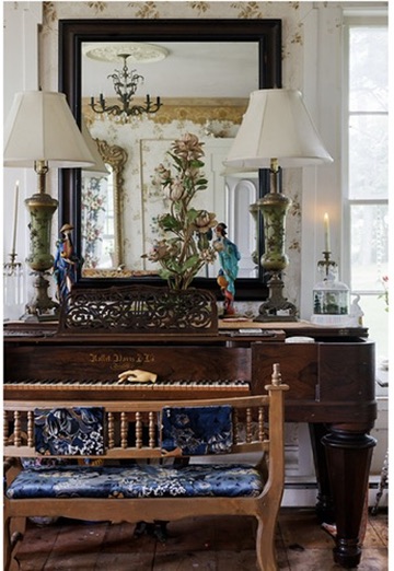 Antique piano beneath a large mirror