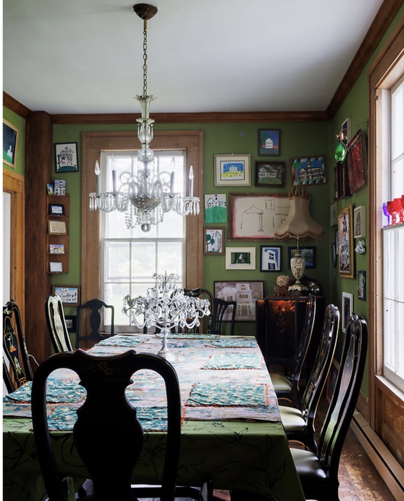 Dining room with green walls and framed pictures