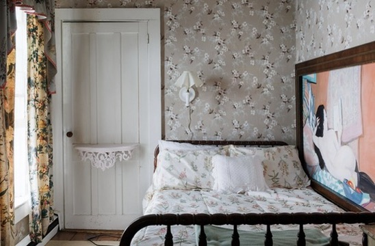 Iron bed in a wallpapered guest room