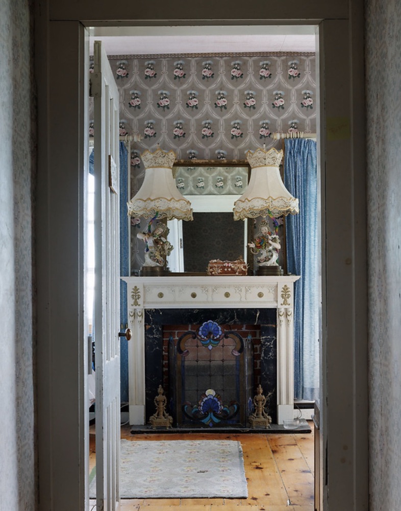 View through a doorway toward an original fireplace