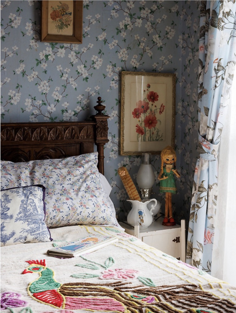 Floral bedding and antique furniture in a guest room