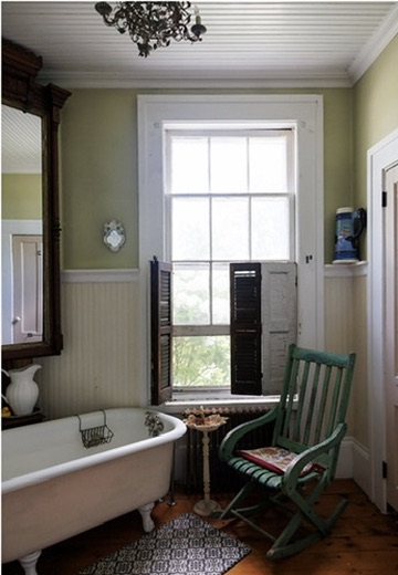 Bathroom with a freestanding tub beside a tall window