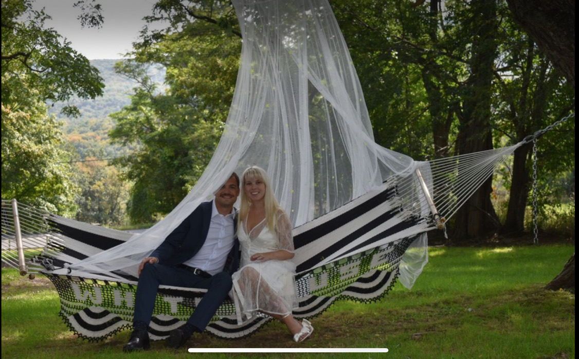 Newlyweds relaxing in a hammock beneath the veil