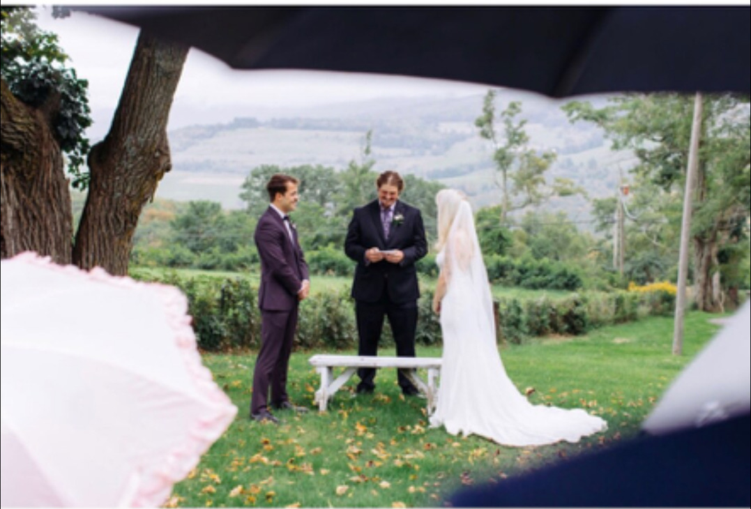 Garden wedding ceremony framed by umbrellas