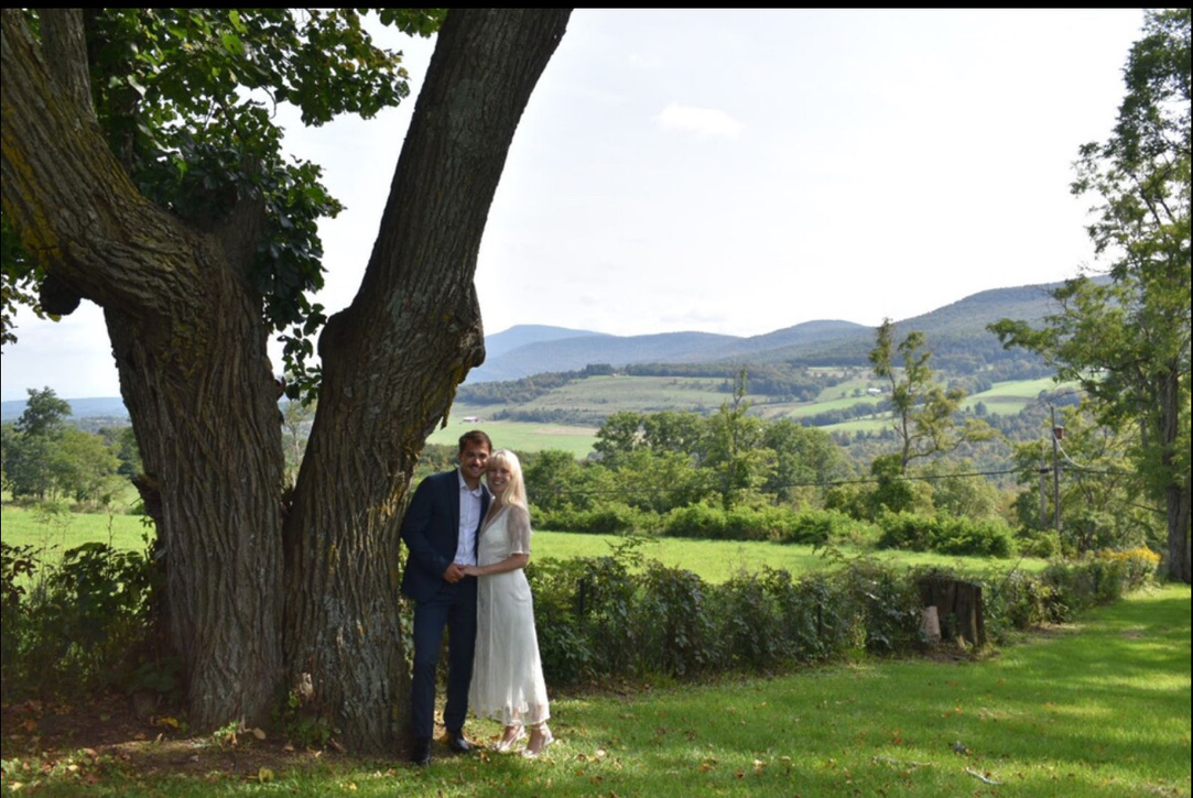 Couple beneath a tree with the hills beyond