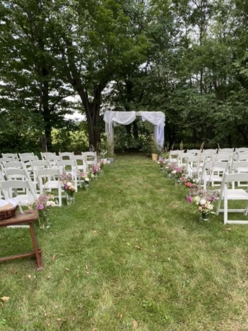 Flower-lined garden aisle and ceremony arbor